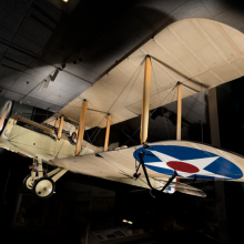 A picture of a beige biplane with a star in a circle on the wing. 