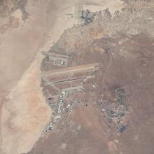 An aerial satellite image of a desert landscape with what looks like various structures in the middle.