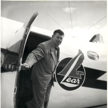 A man stepping out of the door of a small aircraft that says "lear" on its side.