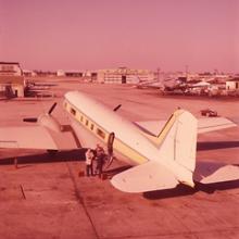 A photo taken from behind the tail of the plane, providing a three-fourths view of the plane from behind. The plane looks similar to a commercial airliner.