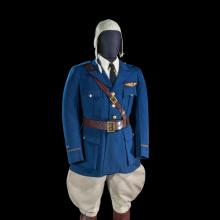 A uniform on a mannequin which includes a deep blue jacket, beige flying hat, beige pants, and tall brown boots.