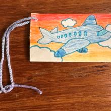 A homemade luggage tag with a drawn on airplane. 