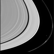 An image in black and white of bands of rings, which take up most of the frame. The outermost visible ring has a large gap between it and the other rings.