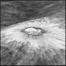 A large hole in the surface of the moon with streaks of light material ejected around it.