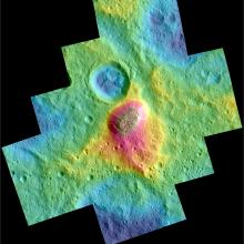 A map showing the topography of a surface. Cooler colors represent low elevation and warm colors represent areas of higher elevation. At the center of the image is a concentration of red.