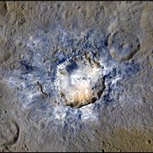 A large blue-colored crater at the center of a brown colored surface.