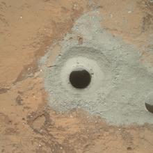 The surface of Mars with a hole bored into it. 