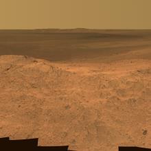 A panoramic view of the dusty red terrain on Mars.