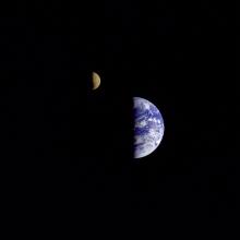 An image of the Earth and the Moon next to each other, the Moon just slightly to the northwest of the Earth. Only the right half of each body can be seen.