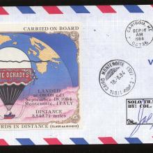 A mail envelope with a USA stamp on it and a postcard with an air balloon attached to it.