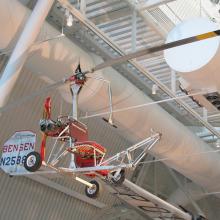 What looks like a seat with a small rudder and with two giant blades suspended above it. 