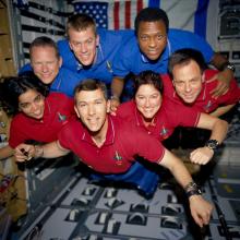 A crew of seven astronauts floating in zero garvity.