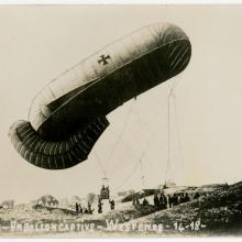 A balloon being pulled down by a group of people.