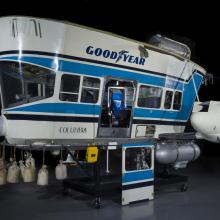 A control car for a blimp, this is painted blue and white and has the Goodyear logo on the side.