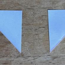 Two small right triangles made of paper.