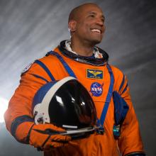 Victor Glover wearing an orange flight suit. 