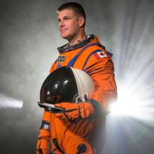 Jeremy Hansen wearing an orange Artemis flight suit