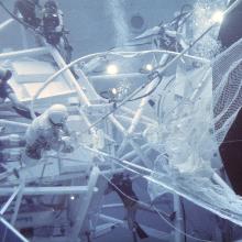 Astronauts and divers underwater working on a space simulator