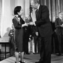 Photograph of Gerald Ford handing a woman an award.