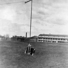 A camera hangs from a wire, elevated off the ground.