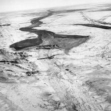 An aerial photo of a once used dam and died out canals around it.