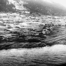 An aerial photo of a small city on the coast that lays mostly in ruin.