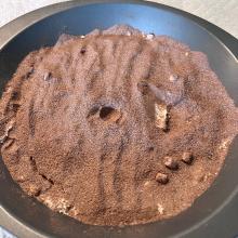 Brown flour-like substance in a silver bowl. There's a divet in the center. 