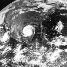 A satellite view of the southeastern part of the United States. A large storm swirls in the Gulf of Mexico.