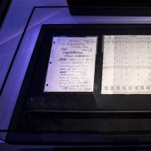 A handwritten letter describing the discovery of rings around Uranus next to a chart demonstrating the discovery. Both are in a display case.