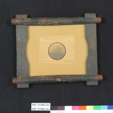 A circular image of a telescope with text around it describing the telescope. The image and accompanying text are mounted on a wooden frame.