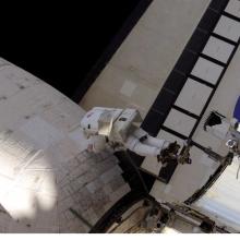 Astronaut working exterior of a Space Shuttle.