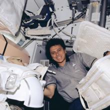 An astronaut floats in zero gravity inside of a space vehicle without a spacesuit.