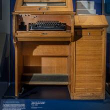 A keyboard sits in a wooden oak cabinet.