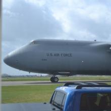 Closeup of a large aircraft as it taxis on a runway.