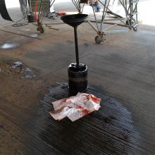 A device is on top of oil on a pavement.