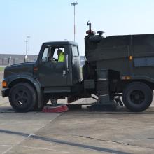 A truck sweeps on a runway.