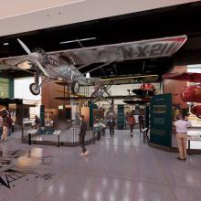 An artist's concept of the Barron Hilton Pioneers of Flight exhibition. In the center is a hanging silver airplane, a red airplane peaks out of the right. There are vertical panels with information on it.