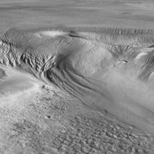 A grayscale image of the surface of mars, showing a textured surface. 