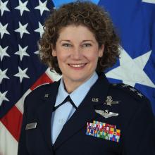 A woman in military uniform smiles for a portrait.