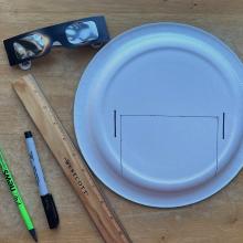 Materials used to create a safe eclipse solar viewer, including glasses, a plate, a rule, pen, and pencil. 