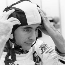 Astronaut William Anders, wearing a white Apollo spacesuit,  adjusts his snoopy cap during preparations for the Apollo 8 mission.