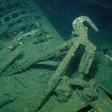 A hook connected to a piece of a wrecked airship underwater.