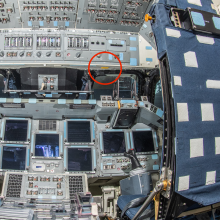 The interior cockpit of a space shuttle, featuring an array of control panels with numerous switches, buttons, and screens, highlighting the intricate operations required to pilot such a craft.