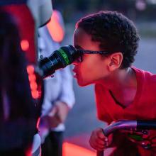 A young visitor looks through a telescope eyepiece