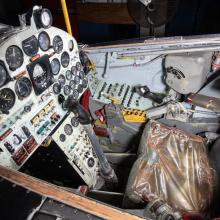 Detailed view of the cockpit of a vintage aircraft, featuring an array of dials, switches, and controls.