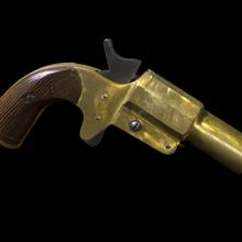 Side view of a yellow painted flare pistol.