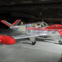 Silver and red painted single engine aircraft with four seats.