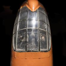 Top view of cockpit of an airplane. The airplane is painted orange and the cockpit window is closed. 