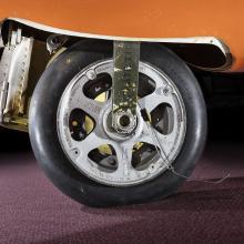  View of a tire on an aircraft. The aircraft is painted orange. 