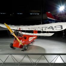 Red and white open-cockpit staggered wing aircraft 